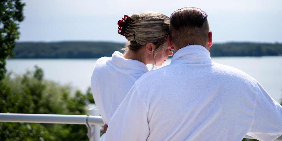 KH-Zweisamkeit-am-See-Sauna-Seeblick Ein Paar steht auf der Dachterrasse des Kongresshotels und blickt auf den Templiner See