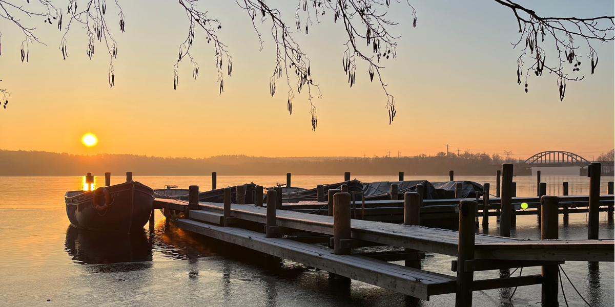 Kongresshotel Potsdam-Außengelaende-Bootsanleger. Sonnenaufgang am Templiner See.