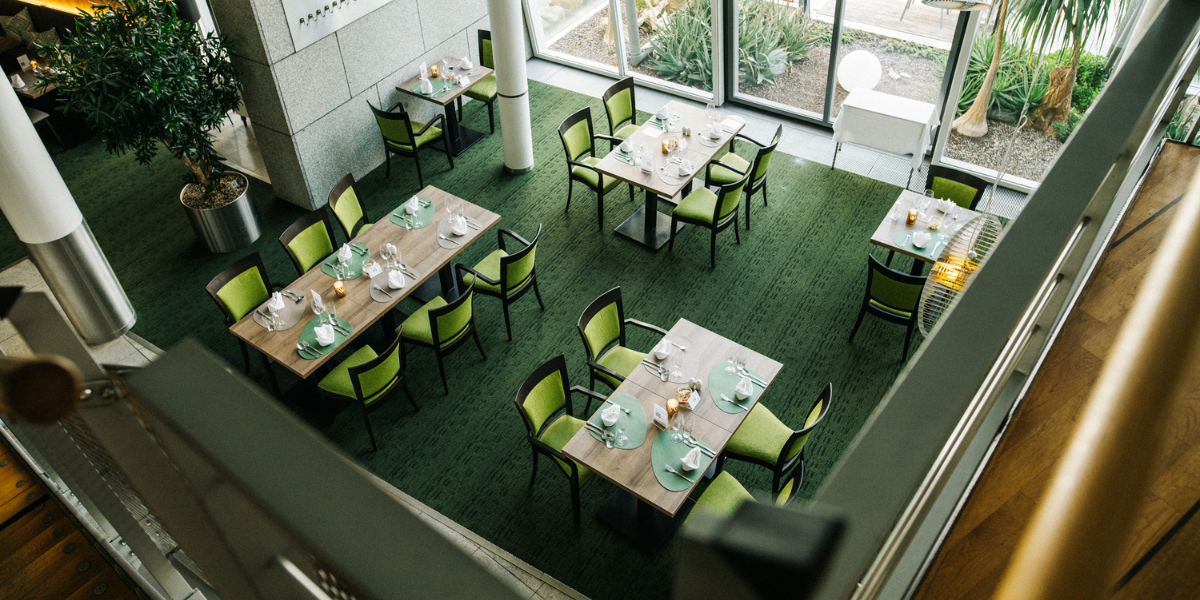 Restaurant Lemon, Tische mit Gläsern und Servietten, grüne Stühle, Panoramafenster