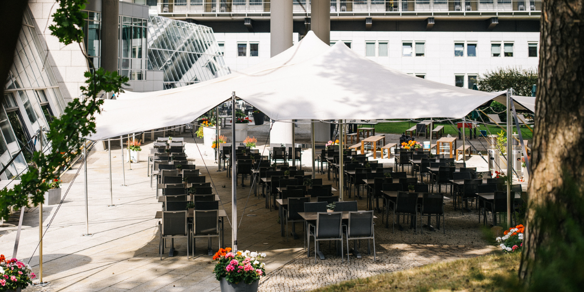 Restaurant Zeppelin, Terrasse, Sonnenschirme, Tische mit Stühlen, Blumen