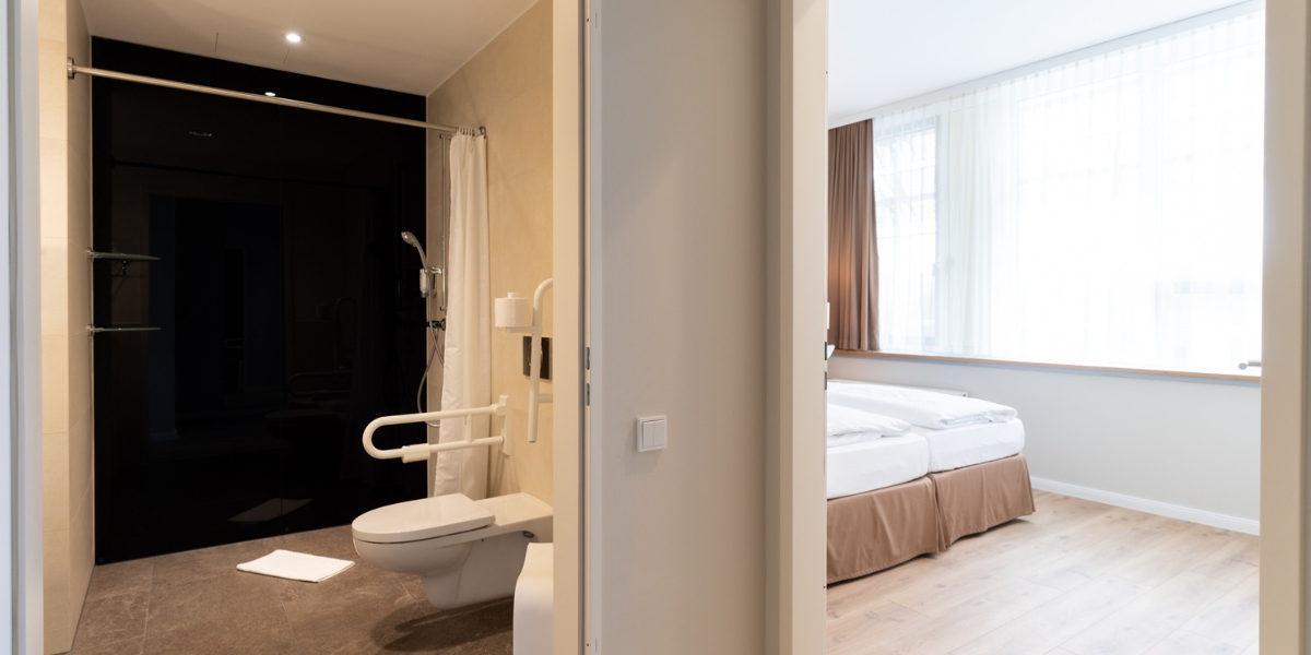 Barrierearmes Studio im Kongresshotel Potsdam. Links der Einblick in das Badezimmer und rechts der Einblick in das Schlafzimmer.