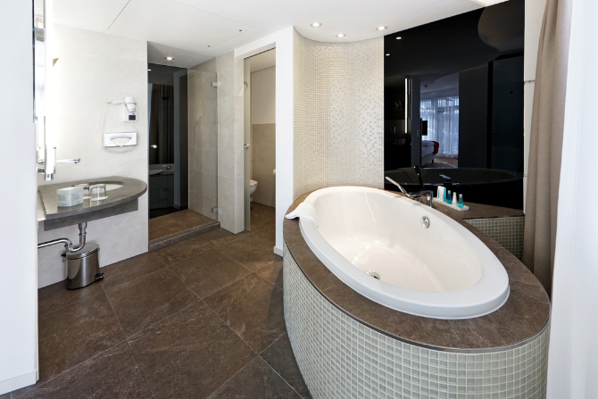 Elegantes Badezimmer in der Deluxe Junior Suite mit Badewanne und Dusche im Kongresshotel Potsdam.