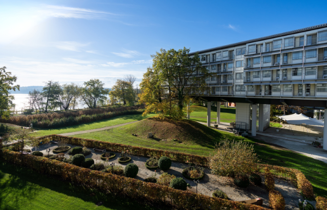 Kongresshotel-Potsdam-Seeblick-Gartenblick Blick auf das Kongresshotel Potsdam mit gepflegten Gartenanlagen und direkter Lage am Templiner See. Die weitläufige Grünfläche und die Uferlandschaft unterstreichen die naturnahe Umgebung des Hotels.